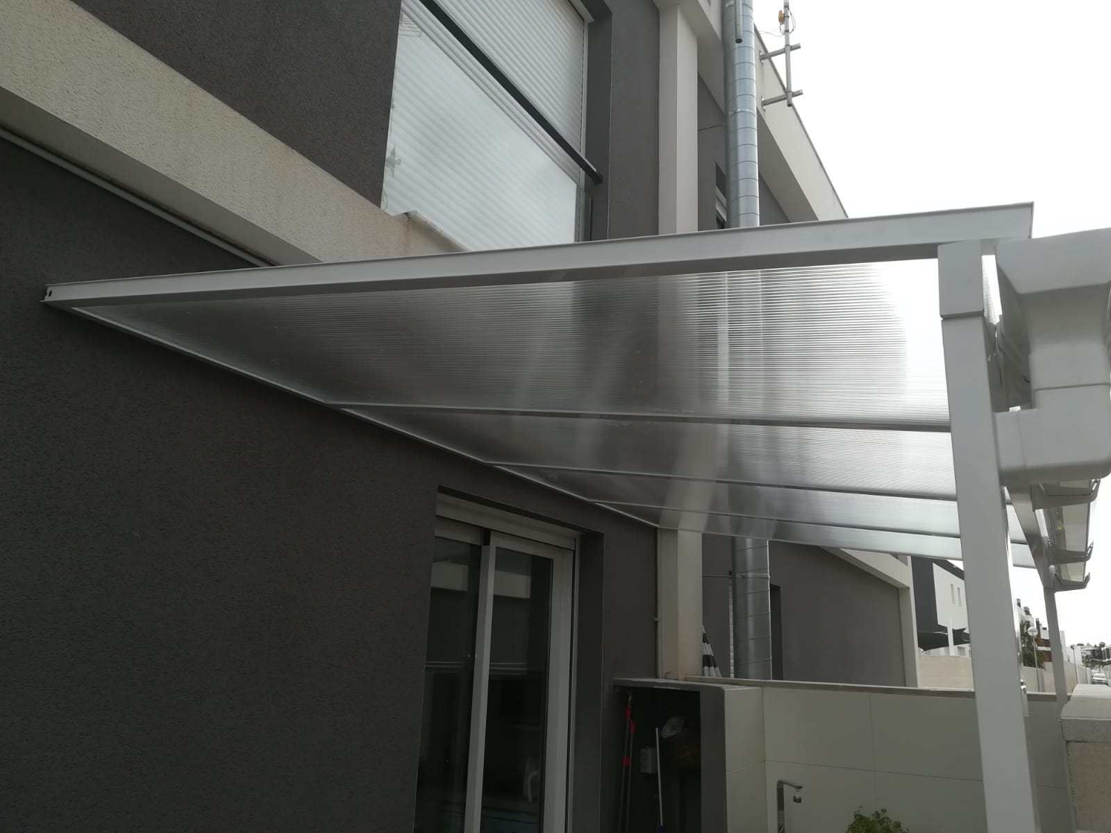 Un edificio con un dosel transparente en el costado.