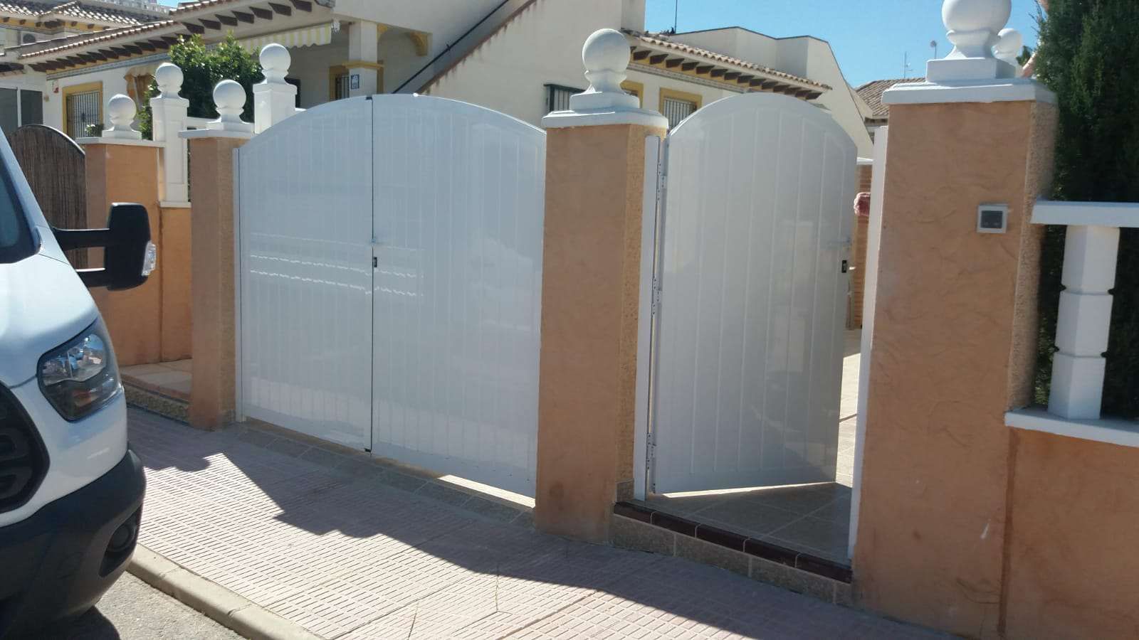 Una camioneta blanca está estacionada frente a una puerta blanca