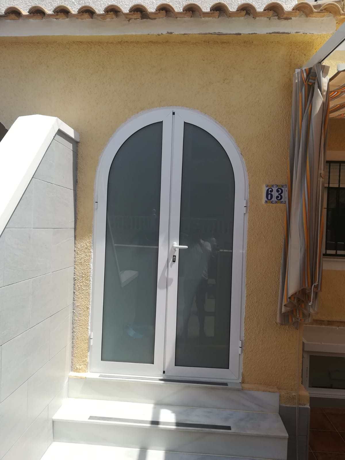 Un edificio amarillo con una puerta y escaleras blancas.