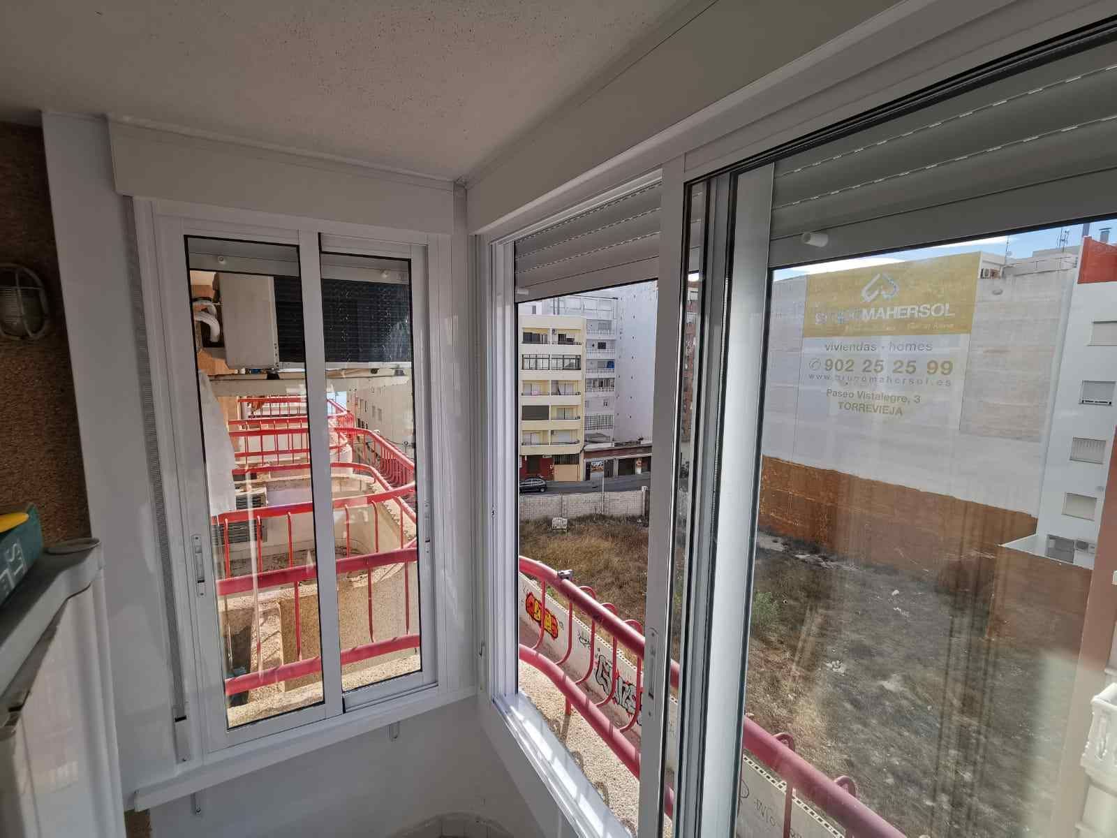 Una habitación con una gran ventana y un balcón.