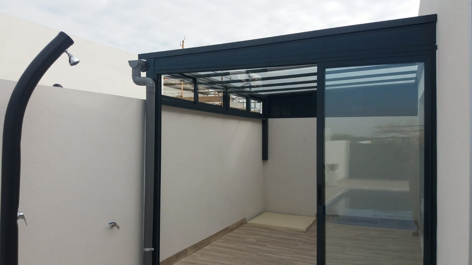 Un patio con una puerta corrediza de vidrio y una ducha.