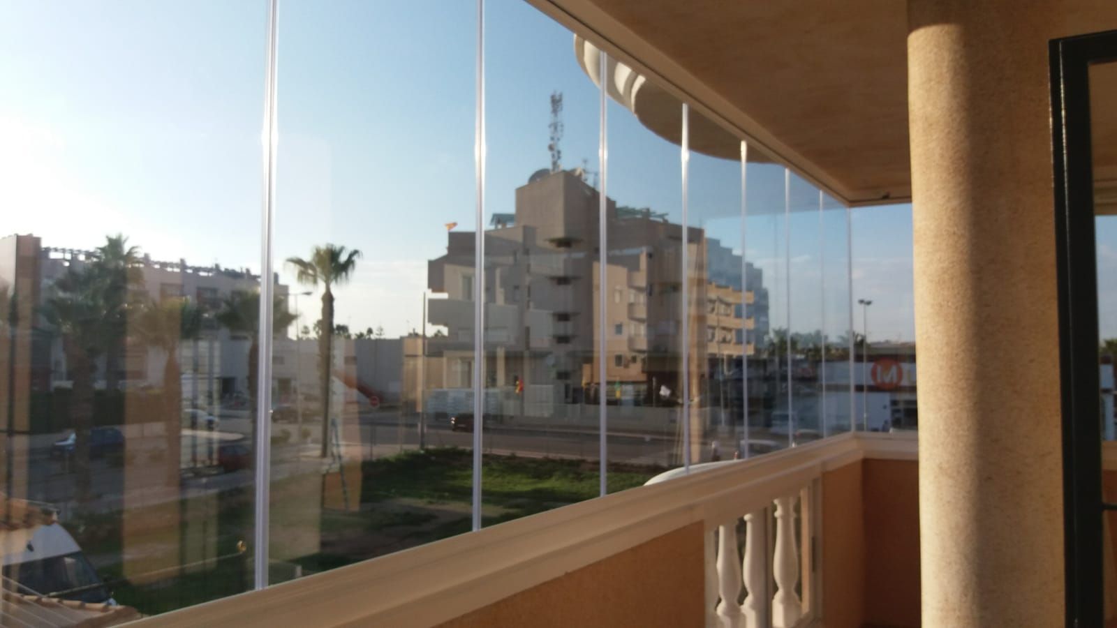 Un balcón con vista a una ciudad y palmeras.