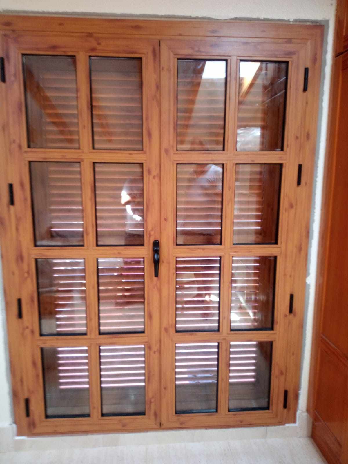 Una puerta de madera con persianas está en una habitación.