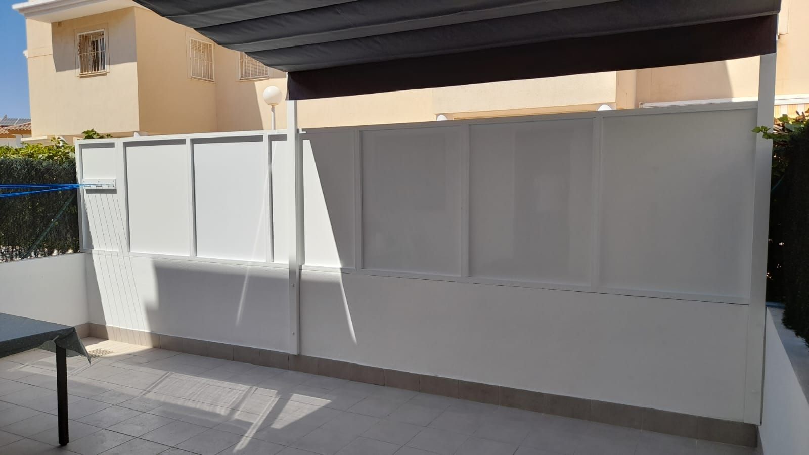 Una valla blanca con una mesa delante.