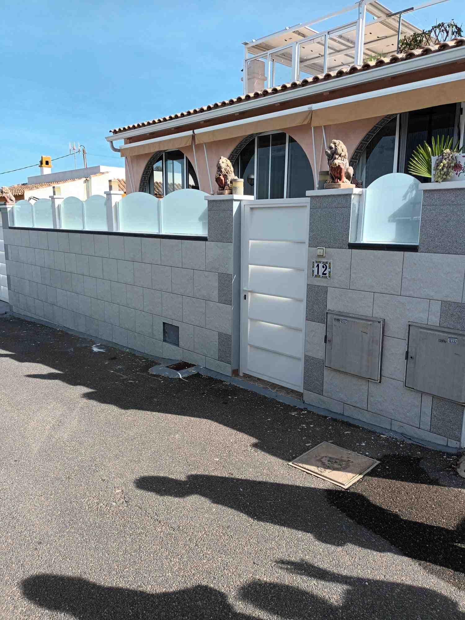 Una casa con una pared de ladrillo y una puerta de cristal