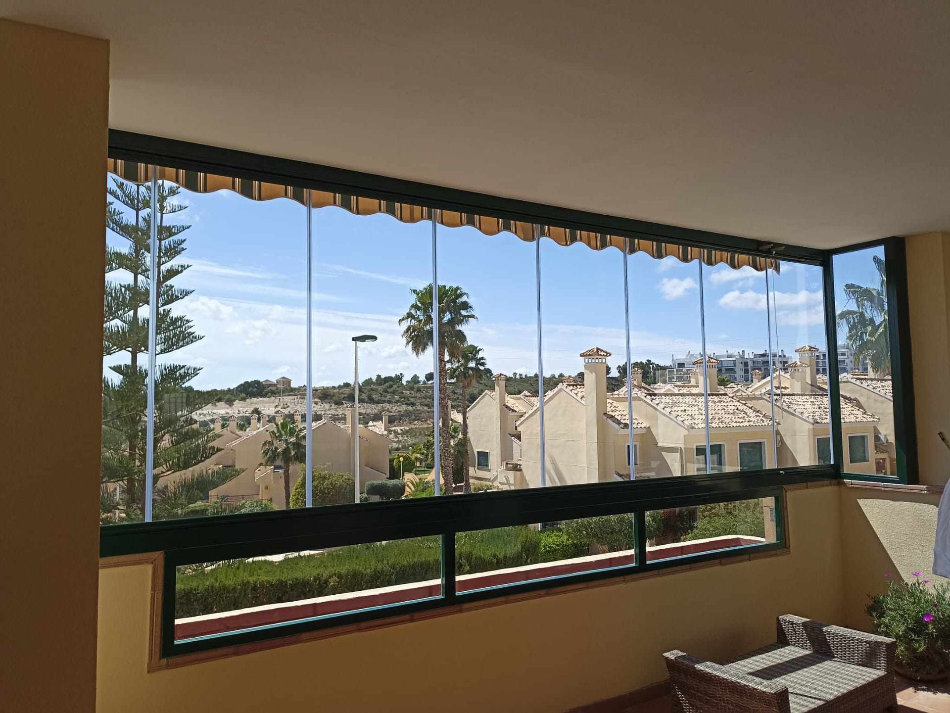 Un balcón con vista a casas y palmeras.