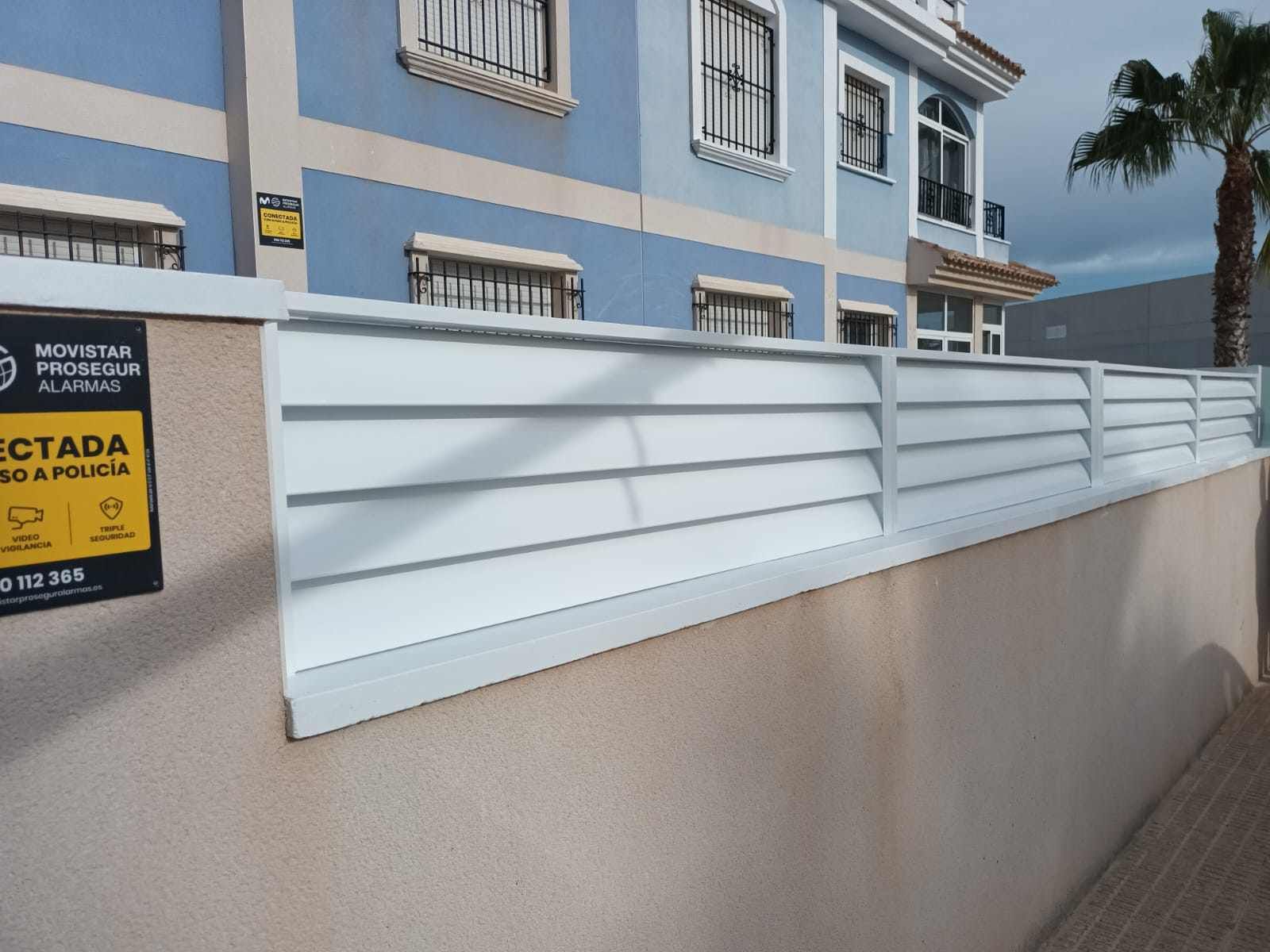 Un edificio con una valla y un cartel que dice rectada