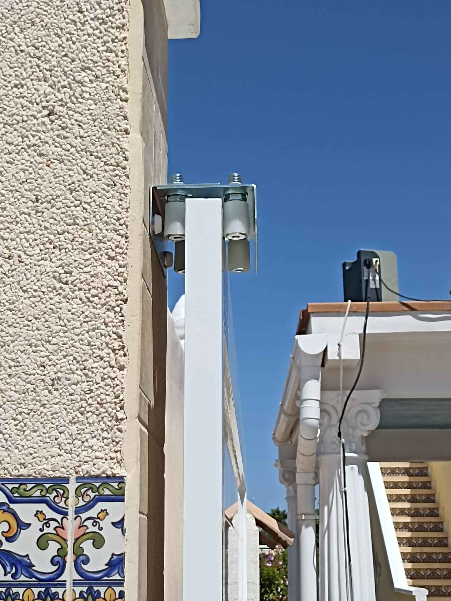 Un poste blanco está fijado al costado de un edificio.