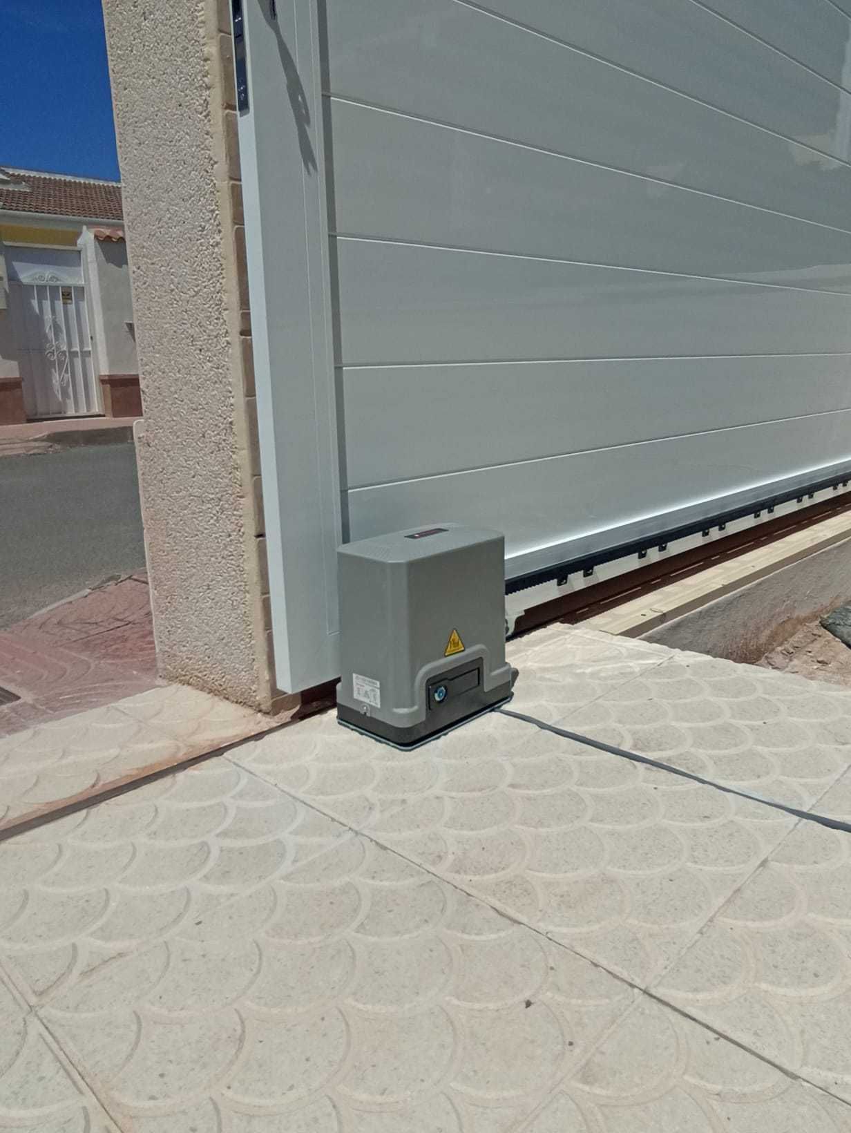 Una puerta de garaje corrediza con un motor acoplado a ella.