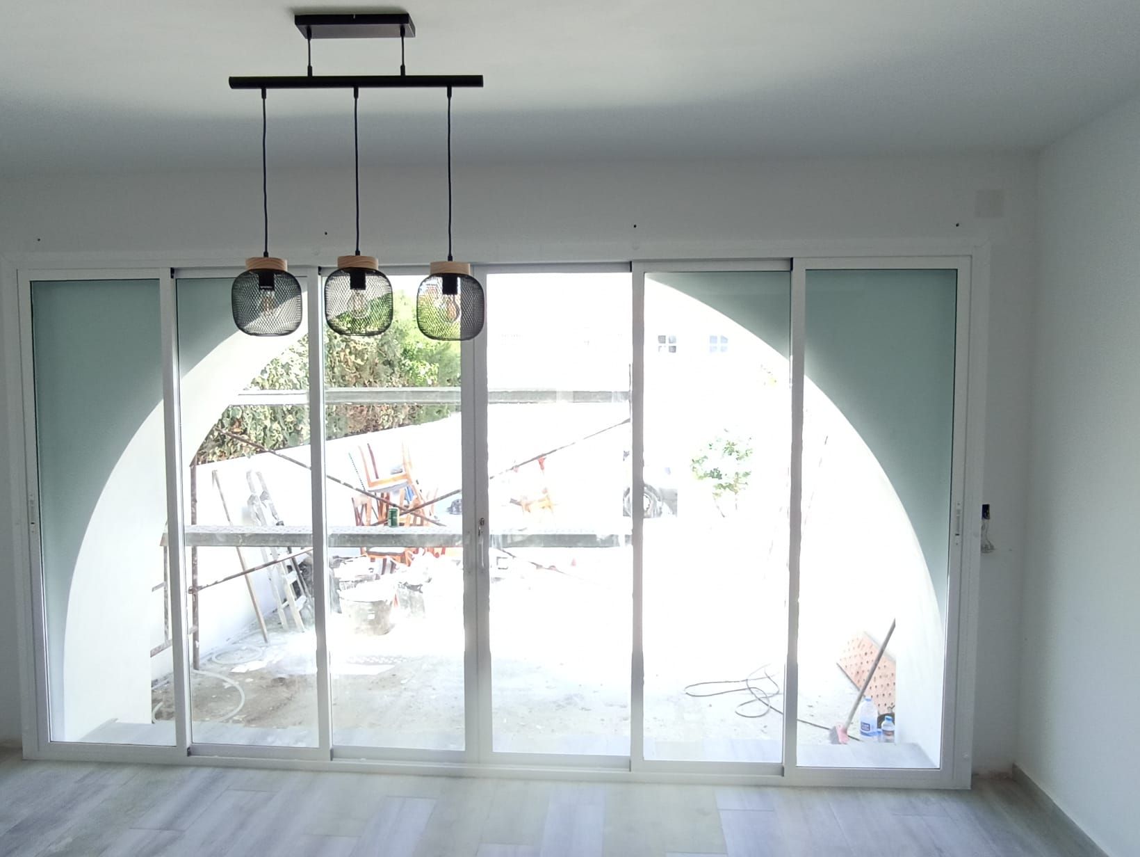 Una habitación vacía con puertas corredizas de vidrio y una luz de techo.