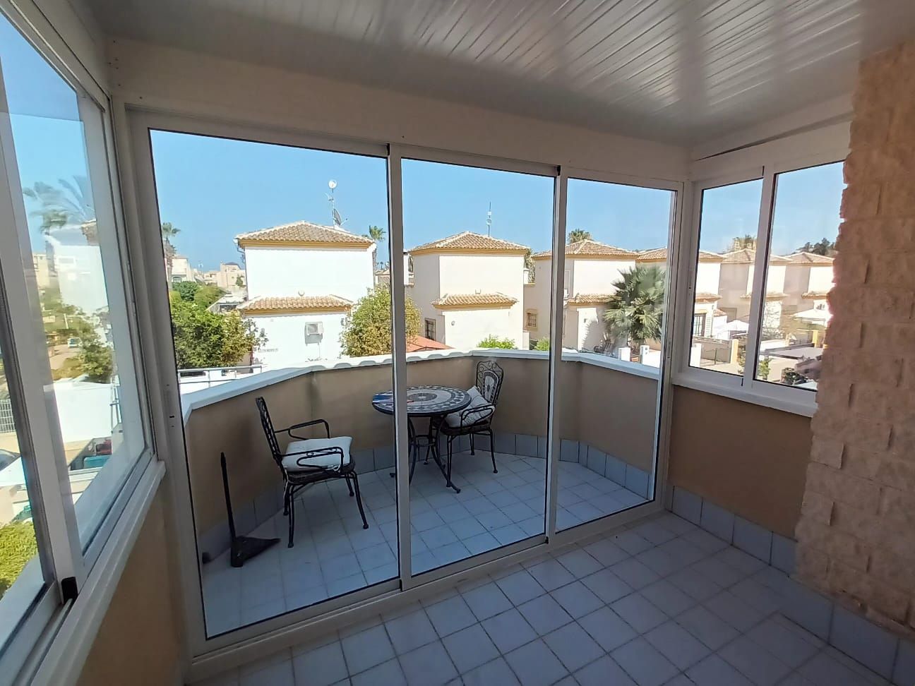 Un balcón con puertas corredizas de vidrio y una mesa y sillas.