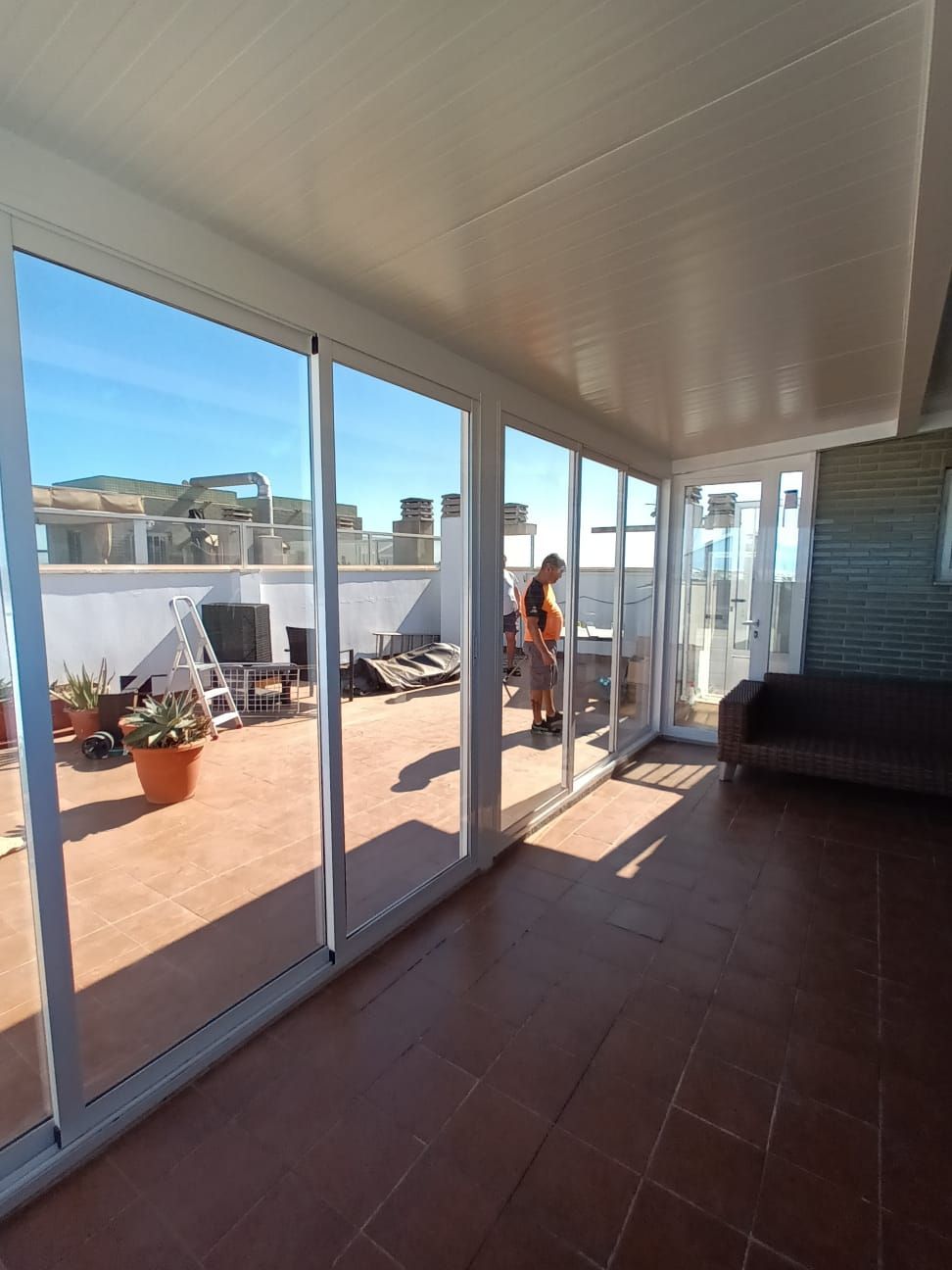 Una habitación con muchas ventanas y un sofá.