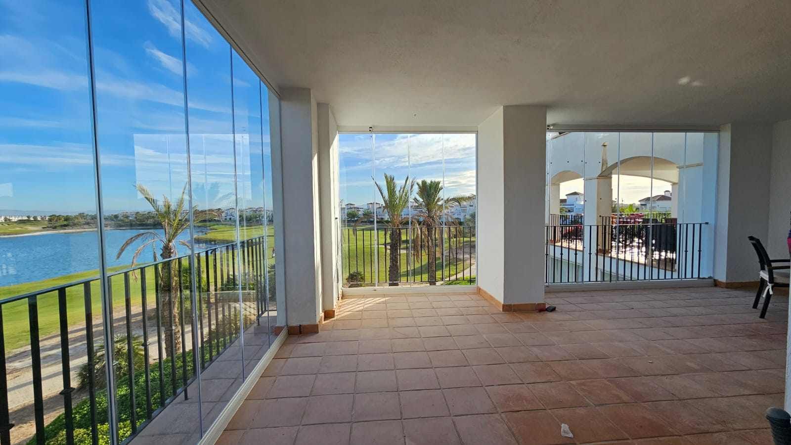 Una habitación grande con muchas ventanas y vista a un lago.