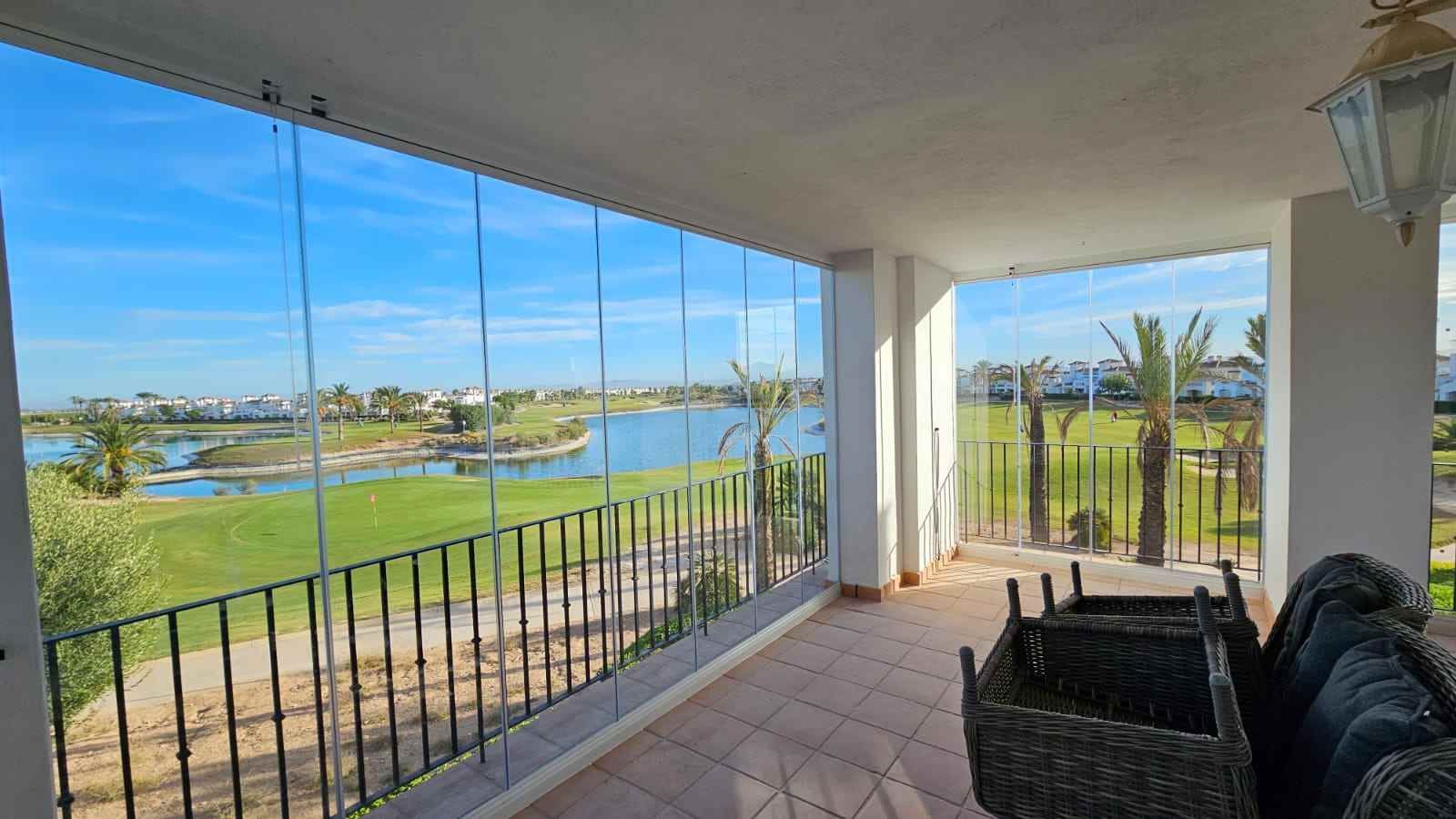 Un balcón con vista a un campo de golf y un lago.