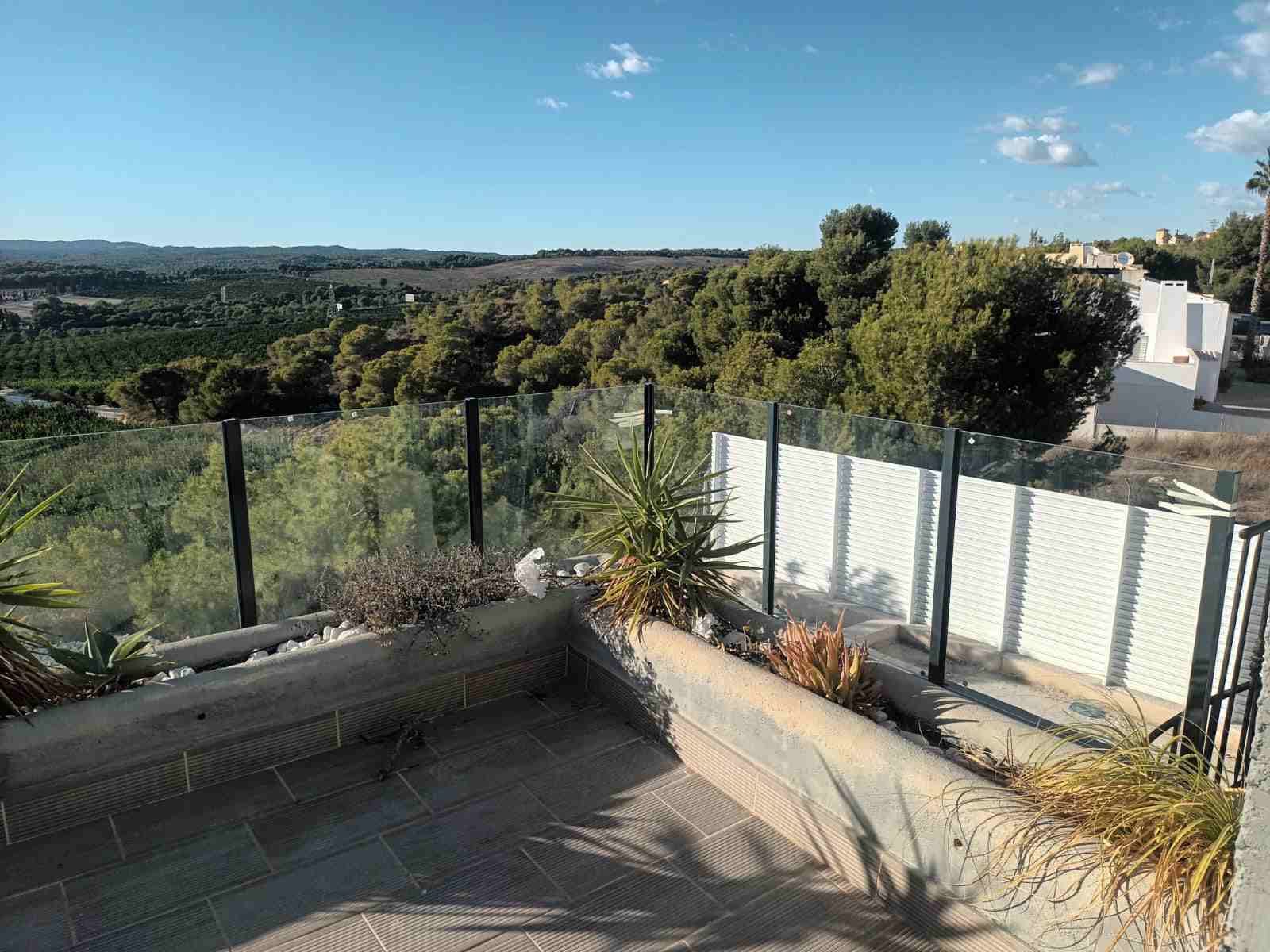 Un balcón con vista al bosque y las montañas.