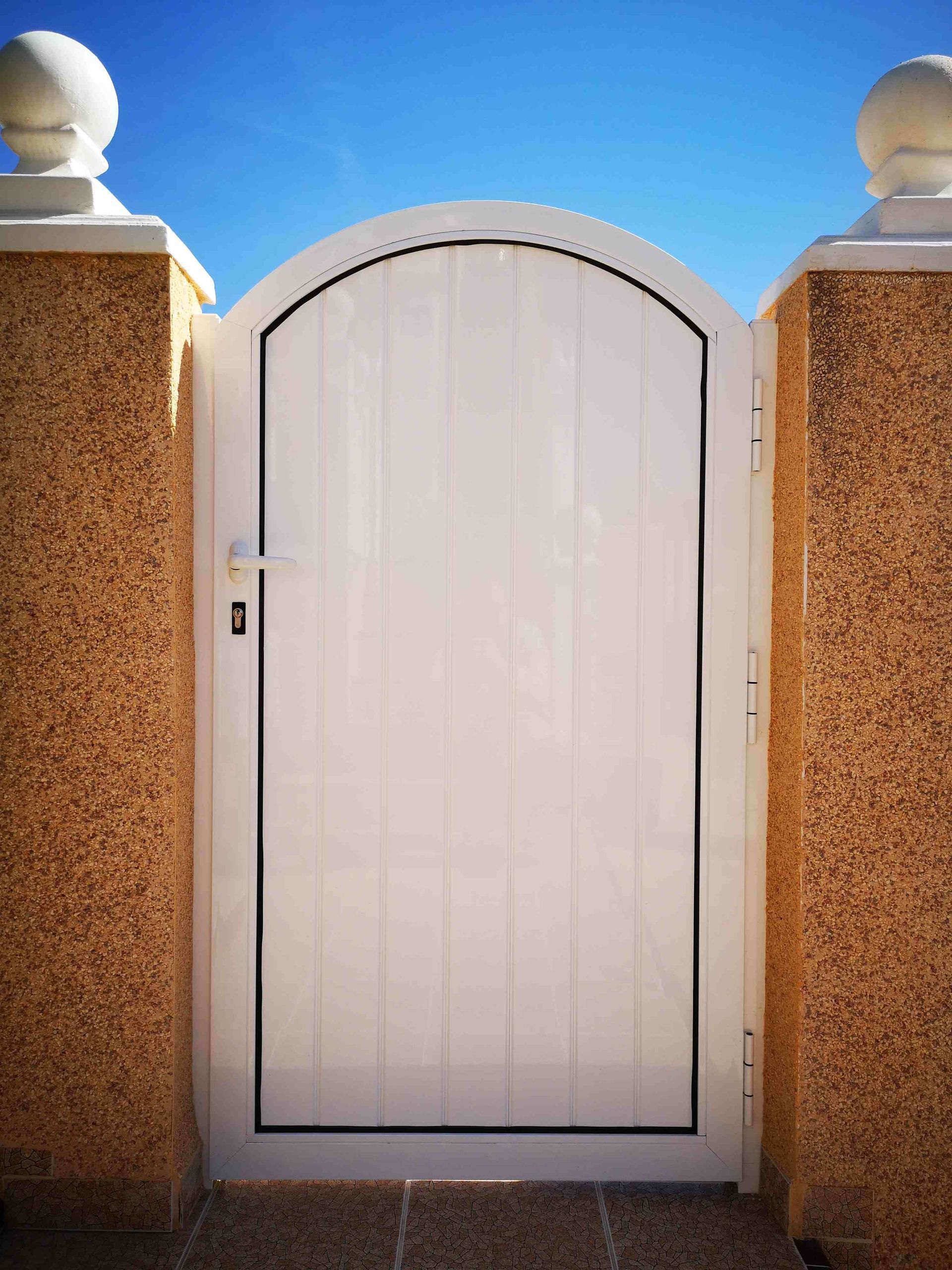 Una puerta blanca con un cielo azul al fondo
