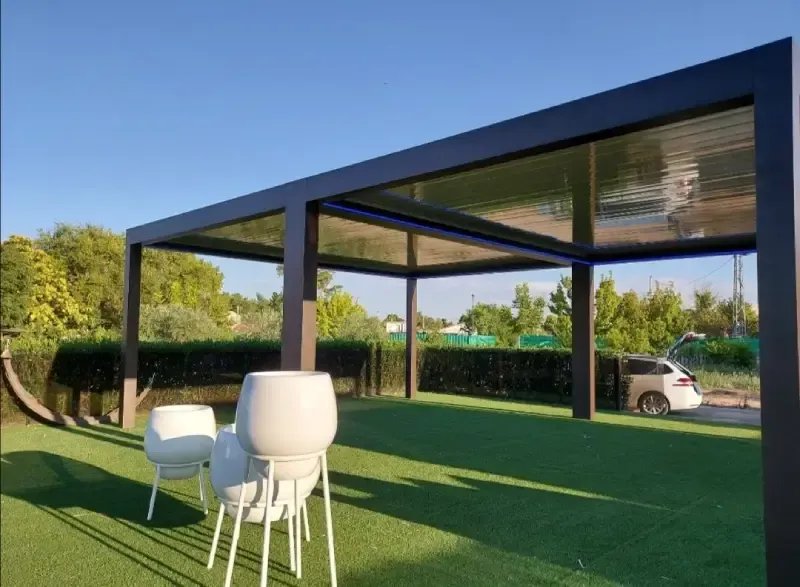 Una pérgola con una mesa y sillas debajo.