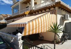 Una casa con un toldo de rayas en el costado.