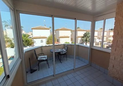 Un balcón con puertas corredizas de vidrio y una mesa y sillas.