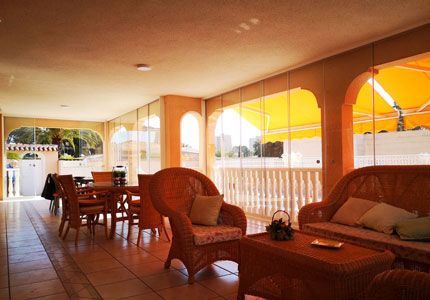 Una sala de estar con muebles de mimbre y un toldo amarillo.