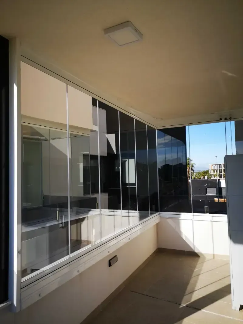 Un balcón con muchas ventanas y una luz en el techo.