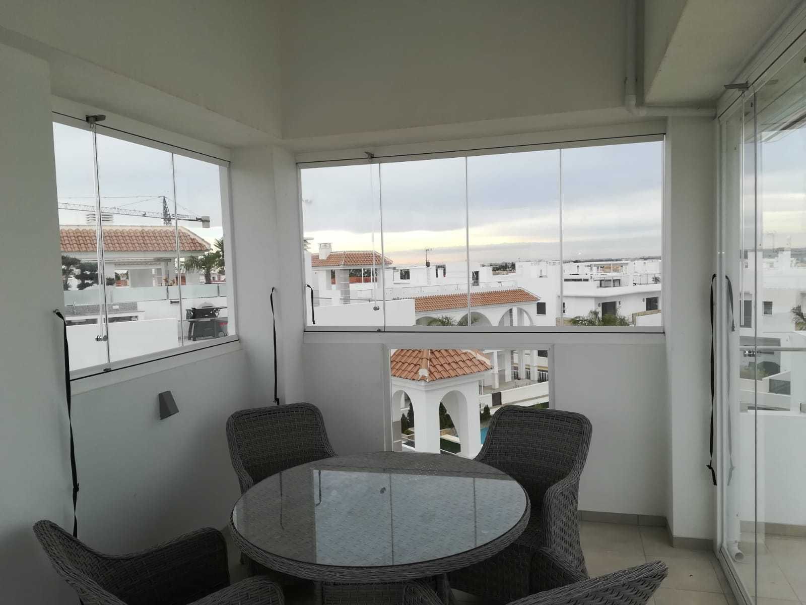 Un balcón con mesa y sillas y vista a una ciudad.