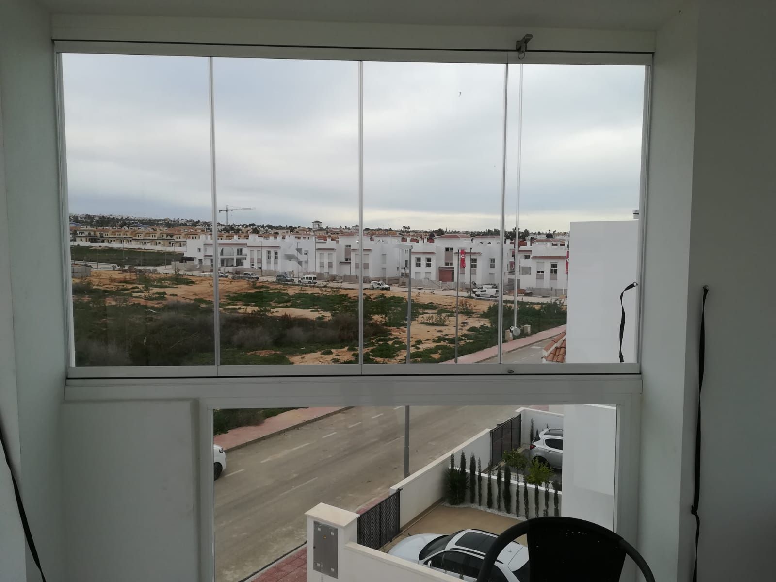 Una gran ventana con vista a una zona residencial.