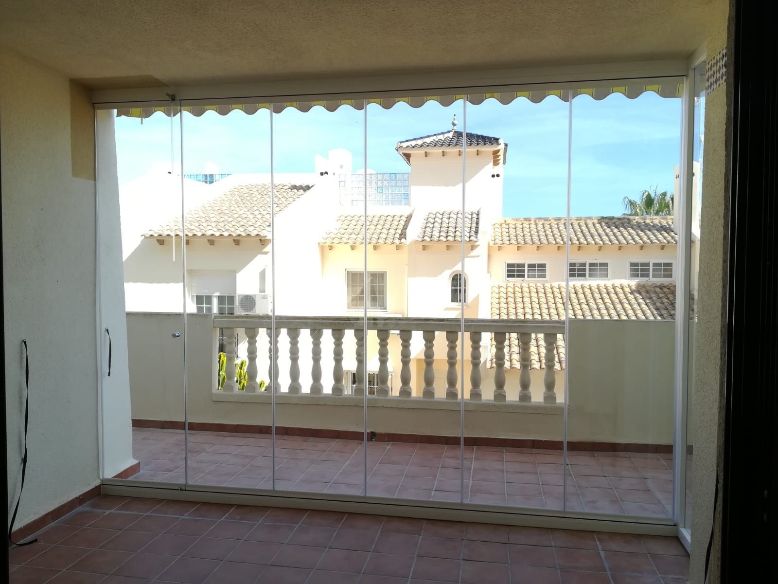 Un balcón con puertas corredizas de vidrio y vista a un edificio.