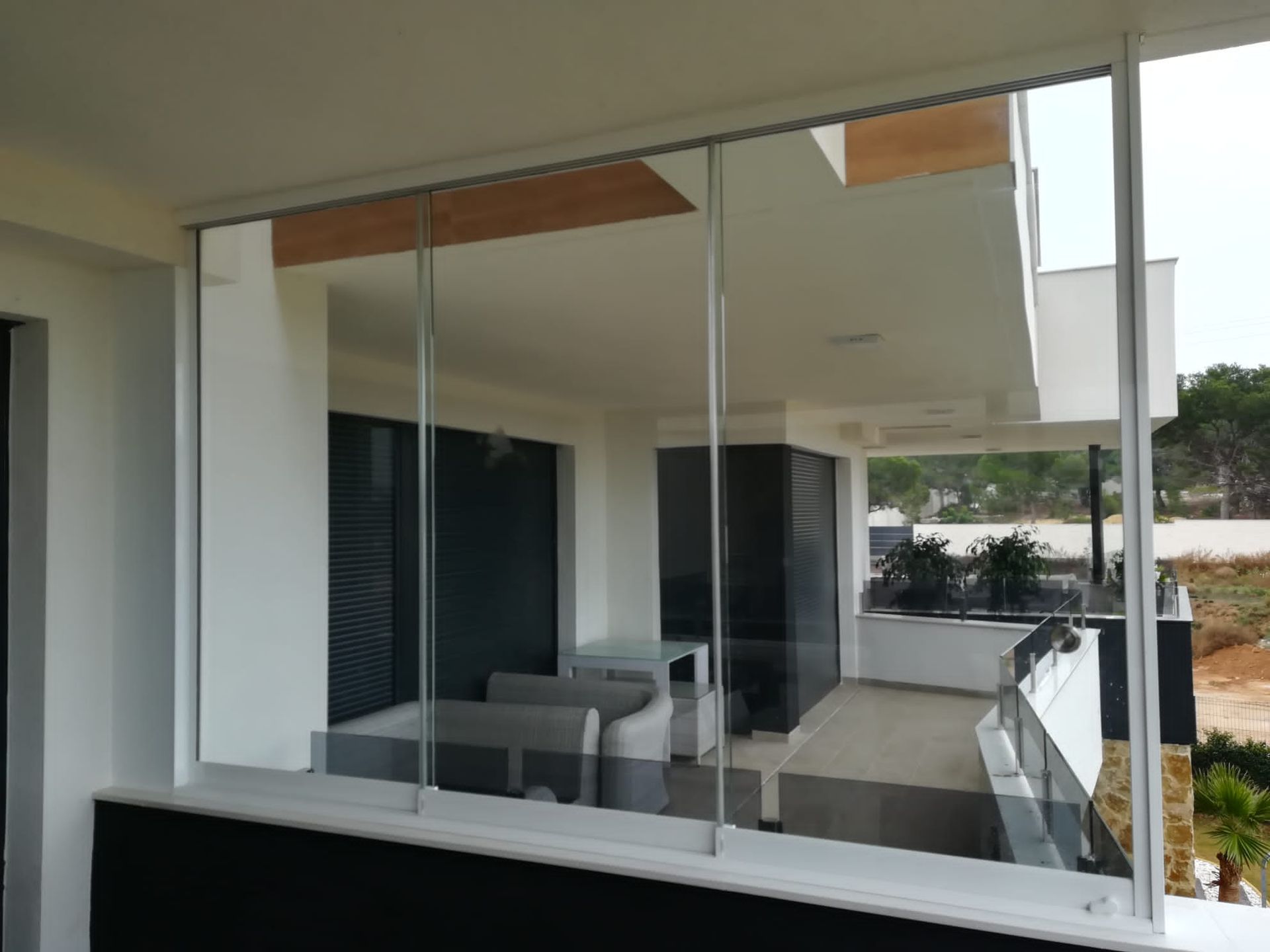 Un balcón con puertas corredizas de vidrio que conducen a un patio.