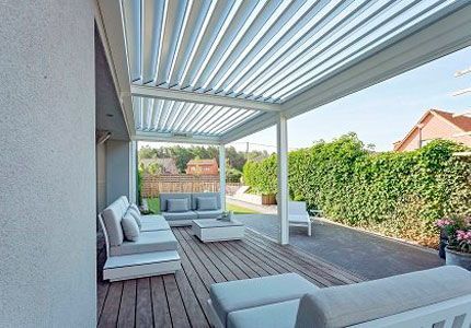 Un patio con una pérgola y un sofá y sillas.