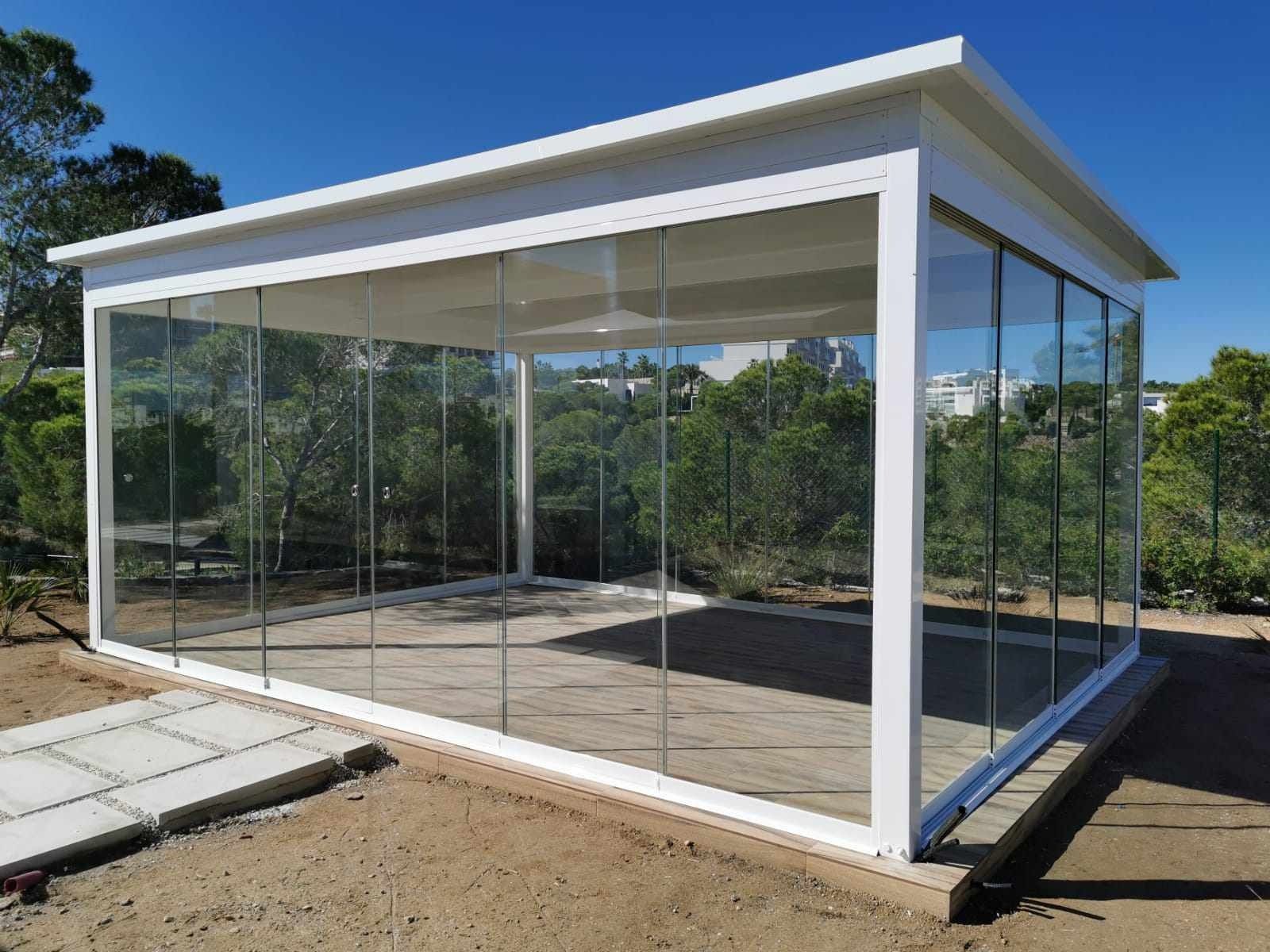 Un edificio blanco con muchas ventanas y árboles al fondo.