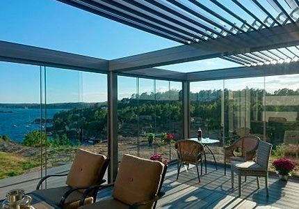 Un patio con sillas y una mesa con vista al mar.