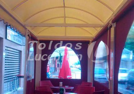 Un restaurante con mesas y sillas y una sombrilla roja.