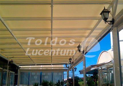 Un edificio con un techo que dice toldos lucentum.