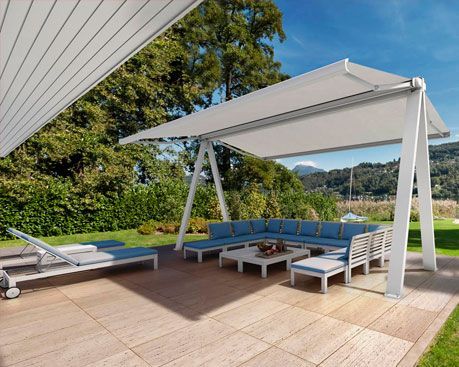 Un patio con dosel, sofá y sillas.