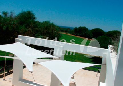 Un paraguas blanco cuelga del costado de un edificio.