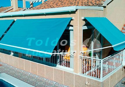 Un balcón con un toldo azul que dice toldos.