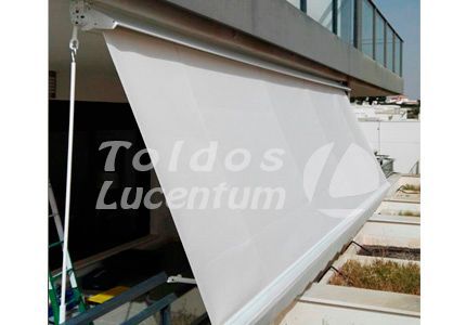 Un toldo blanco cuelga del costado de un edificio.