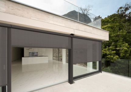 Una casa grande con una puerta corrediza de vidrio y un balcón.