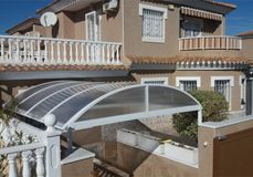 Una casa con un balcón y un dosel en el costado.