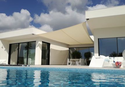 Una casa blanca con una piscina delante de ella