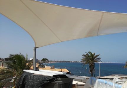 Una gran sombrilla blanca con vista al océano.