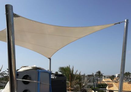 Una gran sombrilla blanca está sobre un tejado.