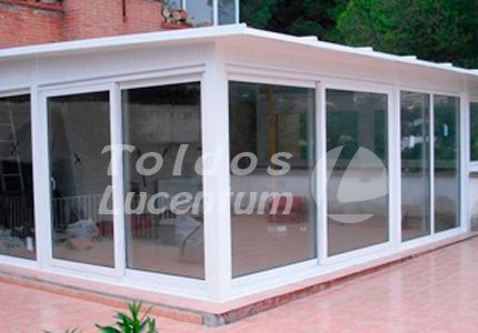 Una habitación grande con muchas ventanas y techo.