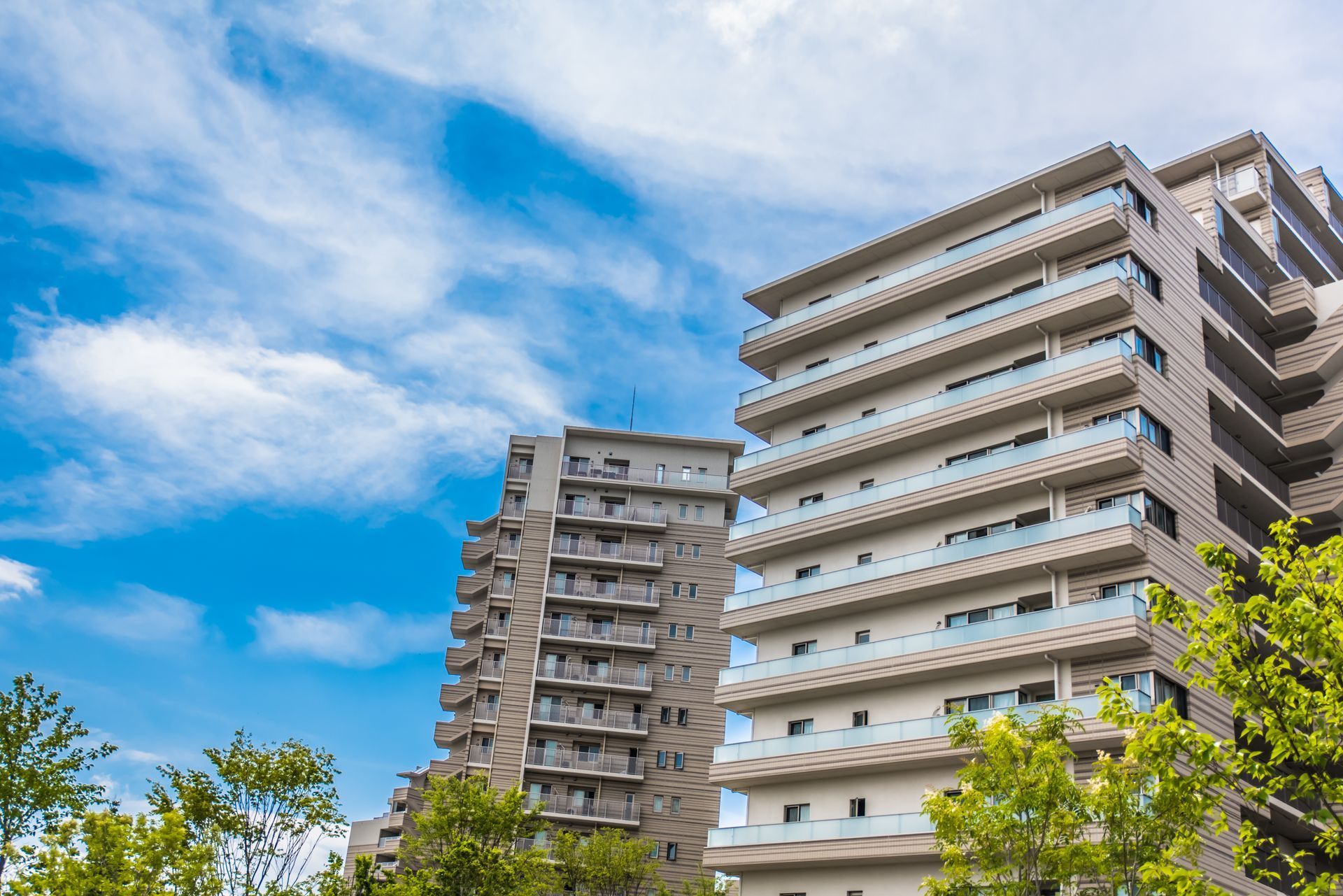 Immeubles d'appartements de grande hauteur se détachant sur un ciel bleu parsemé de nuages.