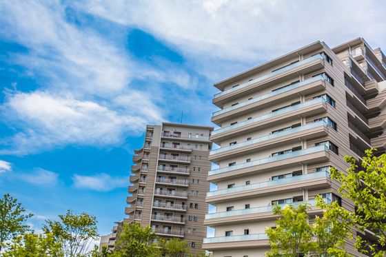 Immeubles d'appartements de grande hauteur se détachant sur un ciel bleu parsemé de nuages.