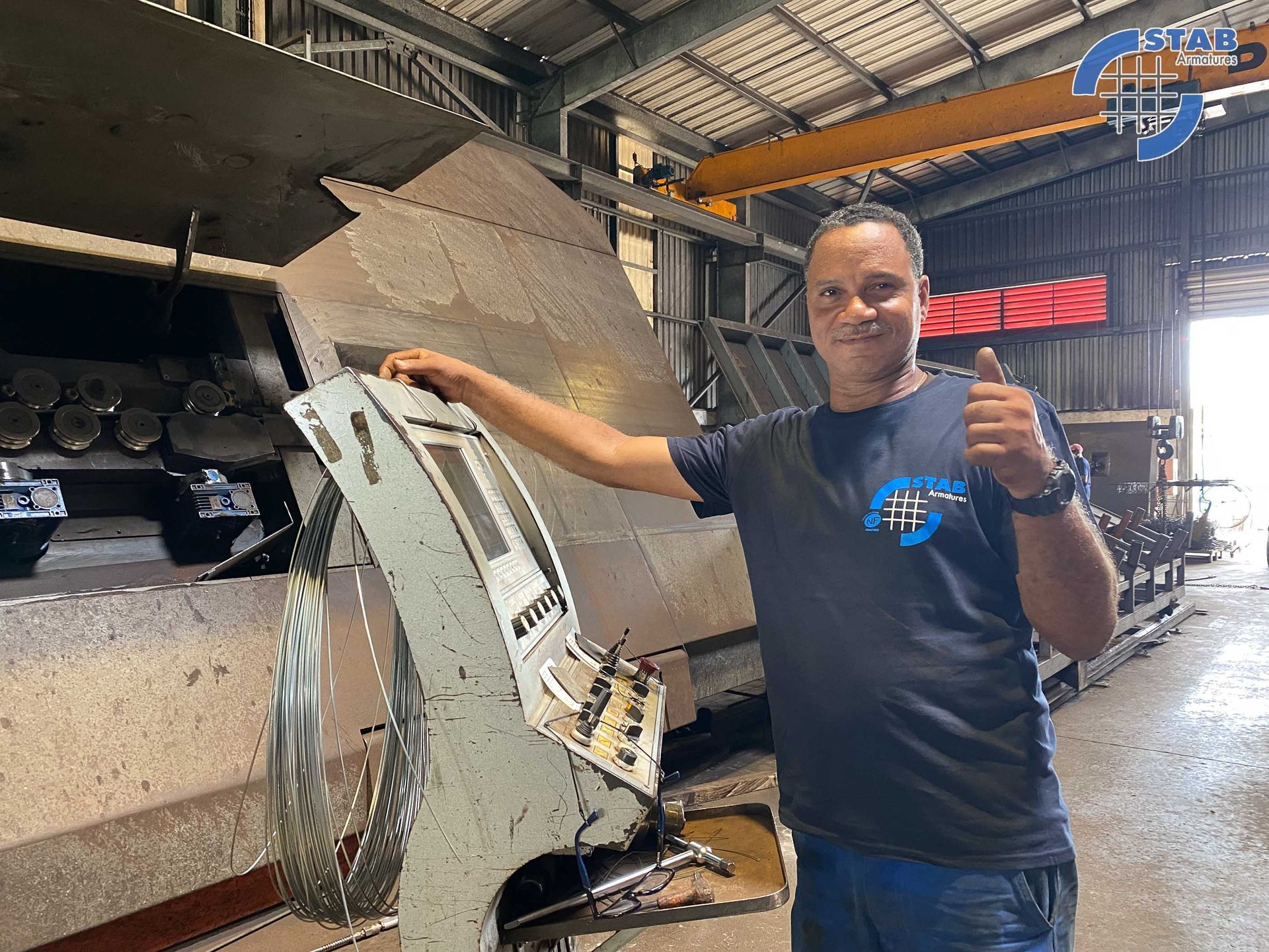 Artisan qui pose à côté d'une machine