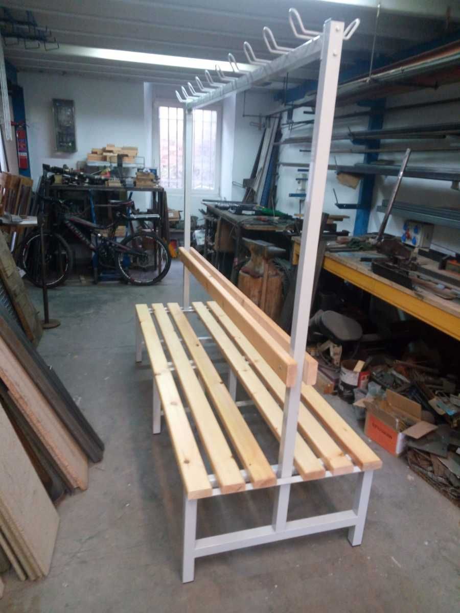 Un banco de madera está sentado en una habitación con una motocicleta al fondo.