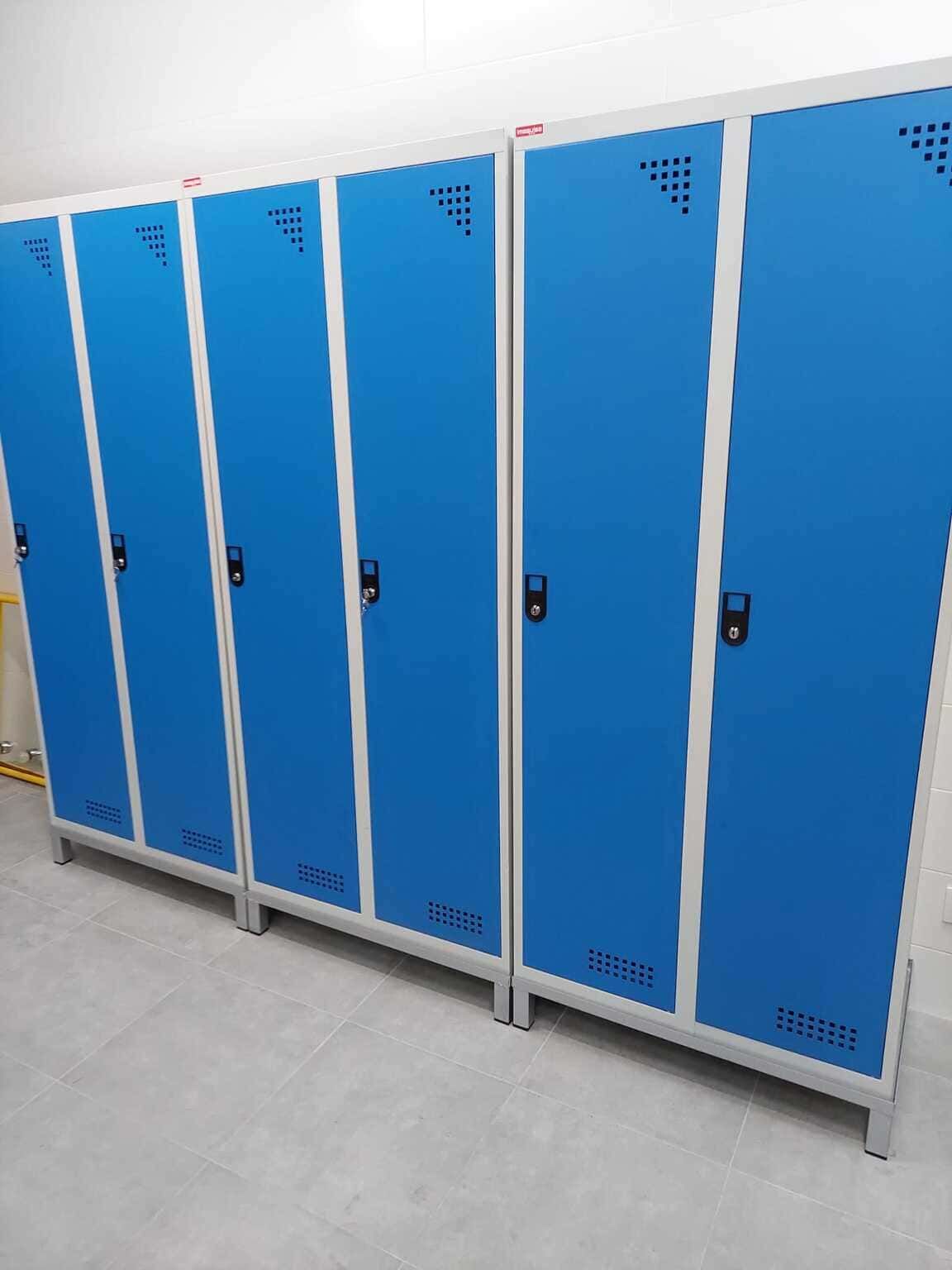 Una fila de casilleros azules están alineados en una habitación.