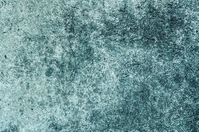 Icono abstracto de paisaje gris con un círculo que simula un sol y colinas onduladas sobre un fondo claro.